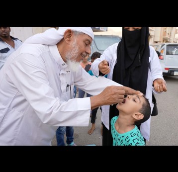 Dr. Nabil vaccinating administering polio drops to one of his grandsons in front of the community to convince people about the safety of the polio vaccine. © UNICEF Yemen