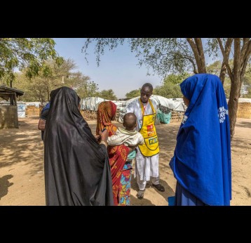 A polio worker speaks to a family in Borno State, Nigeria. In Nigeria, polio personnel have played a vital role to educate communities on COVID-19 and register individuals for their vaccination, underlining the necessity of sustaining these networks. © WHO/Andrew Esiebo