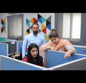 Huma Shaukat, call centre manager, consults with agent Faryal Tariq. Credit: Huma Khawar