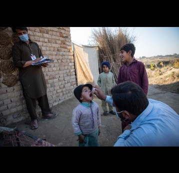 A health worker administering polio drops to a child during nationwide door to door campaign in UC Jalala in Texila, Pakistan. Gavi/2020/Asad Zaidi