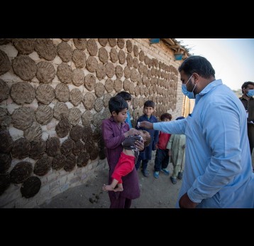 A health worker administering polio drops to a child during nationwide door to door campaign in UC Jalala in Texila, Pakistan. Gavi/2020/Asad Zaidi