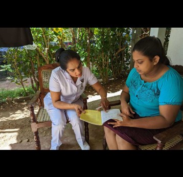 PHM Susangi miss explains to Sithu about the next dose of vaccine that should be administered to her new-born baby. Credit: Aanya Wipulasena