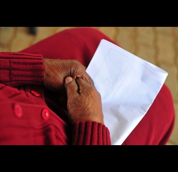 Close up shot of elderly hands on a vaccine registration.