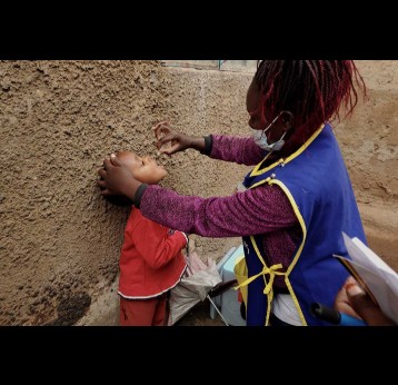 Three and half-year-old Zion Wamala receiving the oral polio vaccine from his parents’ home in Kisugu, on the outskirts of Kampala. His mother, Justine Birungi said the door-to-door exercise has saved her a long walk to a health facility. Credit: Evelyn Lirri