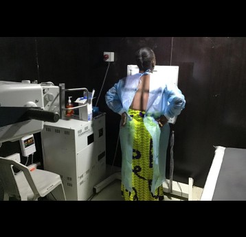 A patient standing in front of an xray machine. Credit: Chioma Obinna