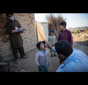 A health worker administering polio drops to a child during nationwide door to door campaign in UC Jalala, Pakistan. Credit: Gavi/2020/Asad Zaidi