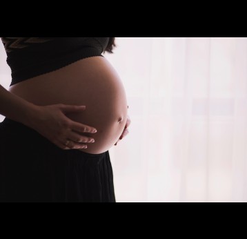 Pregnant woman with her hands on her belly. Credit: freestocks on Unsplash