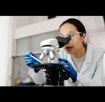 Woman using a microscope. Credit: Edward Jenner on Pexels