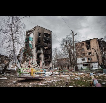 A destroyed house in Borodianka, Ukraine, with a children's play park in front.