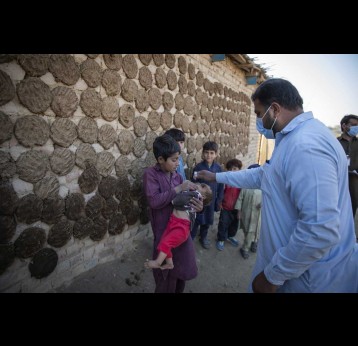A health worker administering polio drops to a child during nationwide door to door campaign in Pakistan. Credit: Gavi/2020/Asad Zaidi