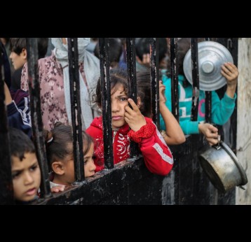 In Rafah, Gaza, children wait for food to be distributed in Dec. 2023. Refugees and survivors or war often suffer malnutrition and stress that can inflict higher rates of chronic diseases later in life. Visual: Ahmad Hasaballah/Getty Images