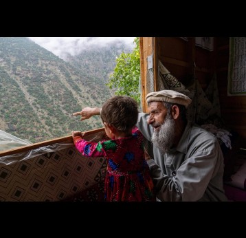Two-year-old Roqia and her grandfather look out over the steep-sided Kamdesh valley in Afghanistan. When she contracted polio in February, Roqia’s grandfather carried her down the mountain for treatment. © UNICEF