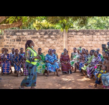 Des agents de santé communautaire animent une séance de sensibilisation sur l'importance de la vaccination de routine auprès d'un groupe de mères au Bénin. Crédit : Edna Fleure