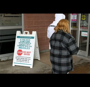 Warning signage for suspected cases of measles is seen outside the main entrance of Woodstock General Hospital in Woodstock, Ont., on May 22, 2025. Credit: THE CANADIAN PRESS, Nicole Osborne