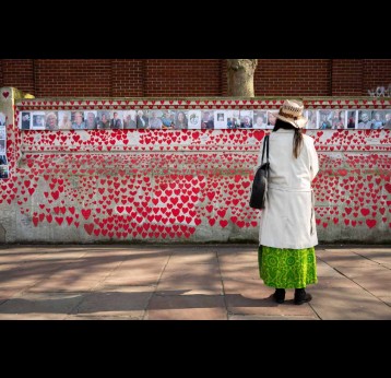 In London, a member of the public observes the National Covid Memorial Wall on March 9, 2025. Visual: Ben Montgomery/Getty Images