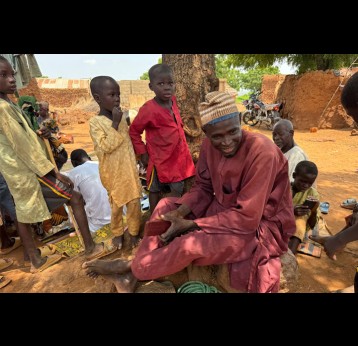 Murtala Aliyu (village head) and children at the CHAN REACH vaccination site providing support in Tung settlement, Wurno LGA, Sokoto State. September 2025. Credit: Maureen Onah