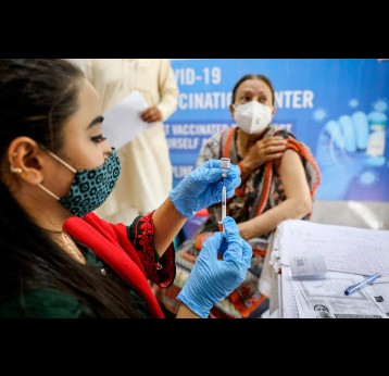A health worker preparing COVID-19 vaccination for a woman at a government vaccination center in Islamabad, Pakistan. Credit: Gavi/2021/Asad Zaidi