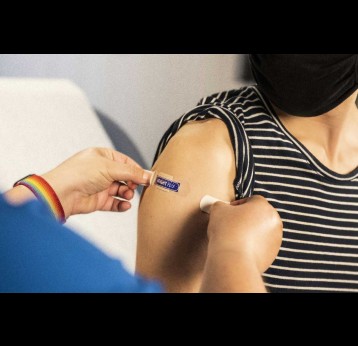A health care provider places a bandage on the injection site of a patient, who just received an influenza vaccine. Credit: CDC/Unsplash