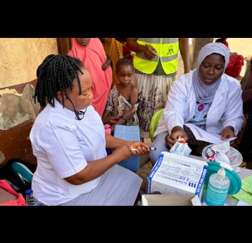 Community Health Worker, Esther O. Daniel, prepares a vaccine at Kuchigoro. Credit: Adnan Ahmad