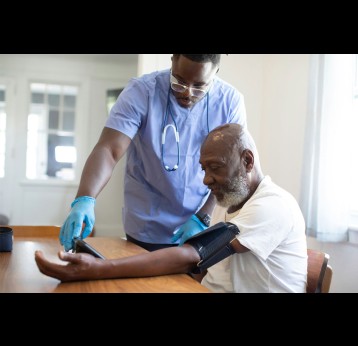 Health worker measuring a patient's blood preassure. Credit: nappystudio via Unsplash