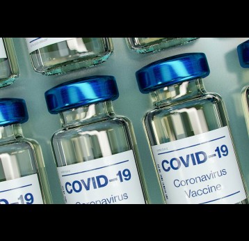 Blue and white plastic Covid-19 vaccine vials. Credit: Daniel Schludi