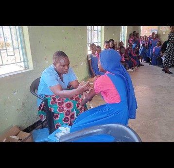 Esther Ndhlovu vaccinating a pupil at Mbayani. Credit: Benson Kunchezera