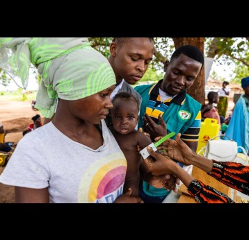 Une mère et son enfant entourés de professionnels de santé lors d’une séance de vaccination au Mozambique. Crédit : Ministère de la Santé du Mozambique.