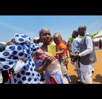 A mother shows her child’s vaccination card after the administration of the malaria vaccine, during the launch ceremony in Kalaban-Coro, on the outskirts of Bamako. Credit: Aliou Diallo