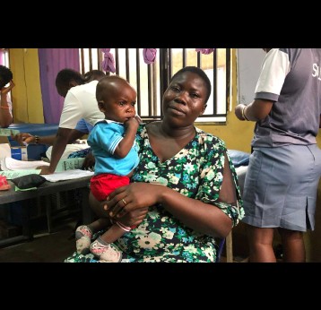 Sandra David holding her child. Credit: Divinewealth