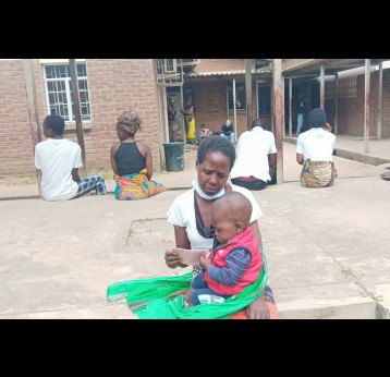 Patuma Mauwa sitting with her last born child who survived Typhoid fever, Ndirande Health Center in Blantyre. Credit: Benson Kunchezera