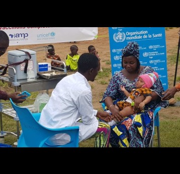 À Togokomé, dans le sud du Togo, une mère tient son enfant pendant qu’il reçoit le vaccin antipaludique R21/Matrix-M, désormais intégré au Programme élargi de vaccination. Crédit : Nephthali Ledy