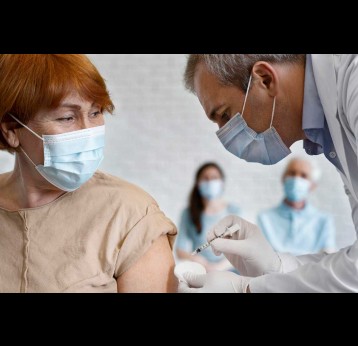 Woman getting vaccine shot by male medic. Credit: Freepik