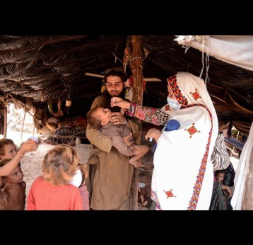 A health worker vaccinates children at a camp in Khyber Pakhtunkhwa. Under the Mobile and Migrant Population initiative health teams seek out such communities to catch up unimmunised children. Photo courtesy: Emergency Operation Centre KP. 