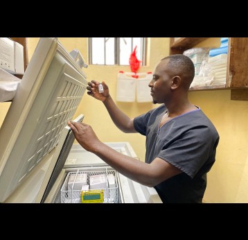Andisa looking at a vaccine vial at the fridge room at Bwindi Community Hospital in southwestern Uganda on January 13. Credit John Agaba