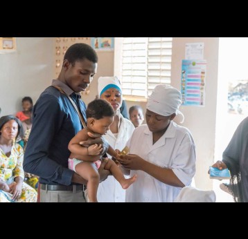 A father and his child at a meningitis vaccination session. Credit: 