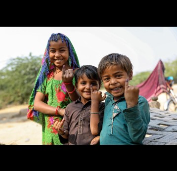Young boys and girls proudly show the ink mark on the tip of their finger. It proves that she has been vaccinated against measles and rubella during the nationwide campaign in Marno Vena village, District Tharparkar. Sindh province, Pakistan. Gavi/Pakistan/Asad Zaidi