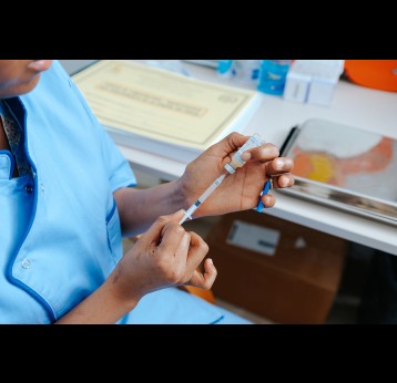 Health care professional prepares vaccine. Gavi/2025/Ollivier Girard