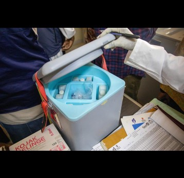 A nurse opens a cold chain vaccine storage box in a health facility. Save the Children/2026/Simon Edmunds