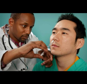 A healthcare practitioner administering a nasal spray vaccine. Credit: CDC