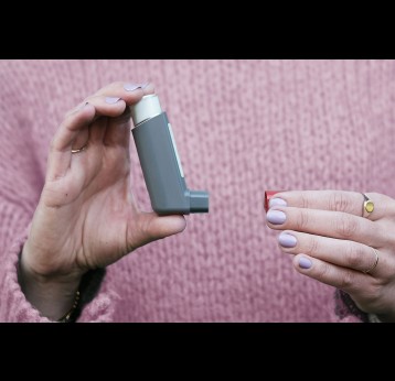 Woman holding an inhaler. Photo by CNordic Nordic on Unsplash