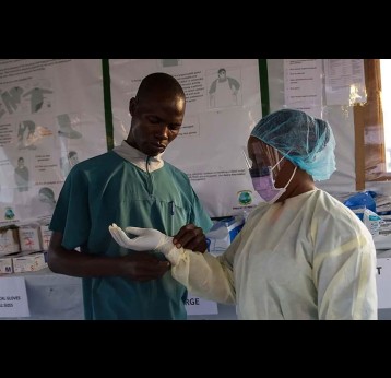 Health personnel dressing up in personal protective equipment (PPE) during a 2015 Ebola outbreak in Liberia. The 2014-16 West Africa Ebola epidemic catalysed a wave of investment in Africa’s response capacity. Copyright: UNMEER (CC BY-ND 2.0)