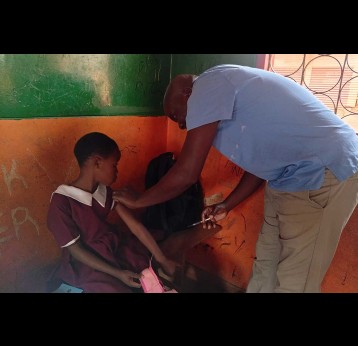 Alick Phiri, a Health Surveillance Assistant, administers vaccine to a student in Blantyre, Malawi. Credit: Josephine Chinele