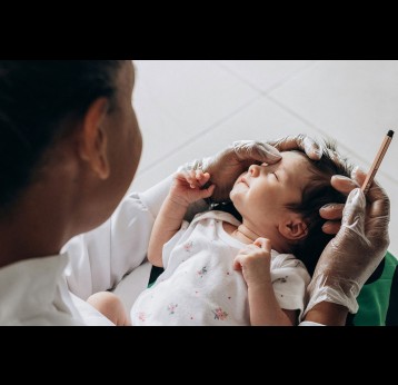 Health worker holding a newborn in her lap. Photo by Jonathan Borba on Unsplash
