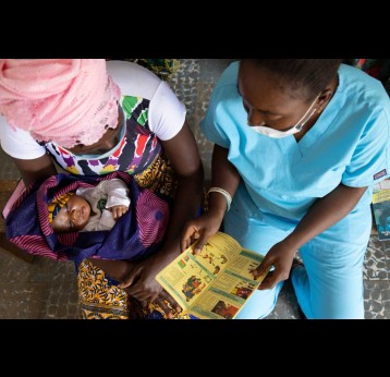 A nurse shares educational materials with mother to protect her family from malaria. Copyright: Raw Pixel (CC BY-SA 4.0)