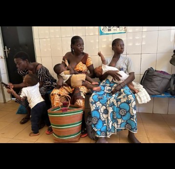 Mothers wait with their children at the Cissin 17 health centre in Ouagadougou, ahead of vaccination and weighing sessions. Credit: Abdel Aziz Nabaloum