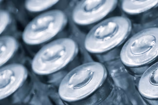 Glass vaccine vials on production line machine conveyor