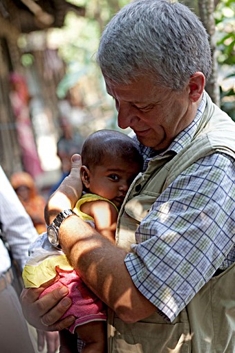 Dagfinn Høybråten cradles a child during his visit to Bara Goan, a village 55km south of Dhaka, Bangladesh