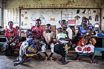 Mothers wait with their children during the introduction of the pneumococcal vaccine in Kenya