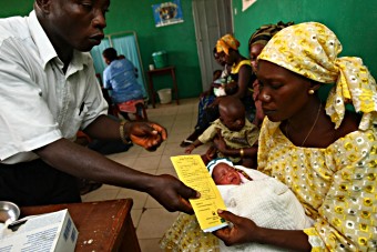 Rwanda - mother being handed vaccine card in health centre