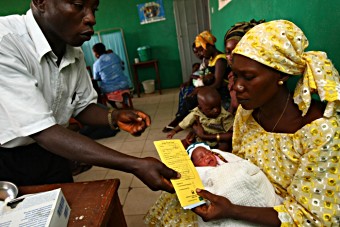Rwanda - mother being handed vaccine card in health centre